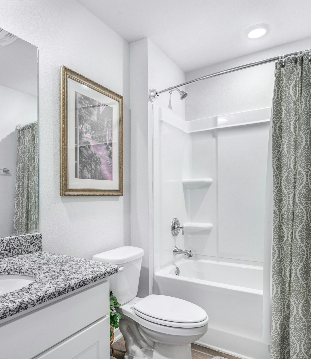 New dark wood bathroom vanity with marble countertop, wall cabinet, and framed mirror installed by J&K Exteriors