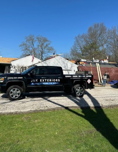 Roofing contractors finishing flashing and ridge cap details on a Stark County home