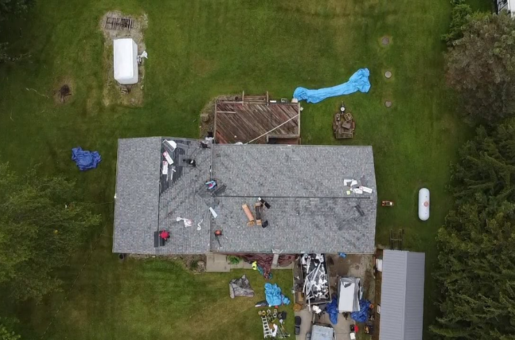 Roof repair technician fixing damaged shingles in North Canton, OH by J&K Exteriors